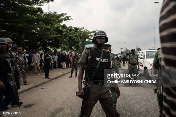 Nigerian police's anti-riot unit secure the main gate of the local office during the protest by supporters of the All Progressives Congress in Port...