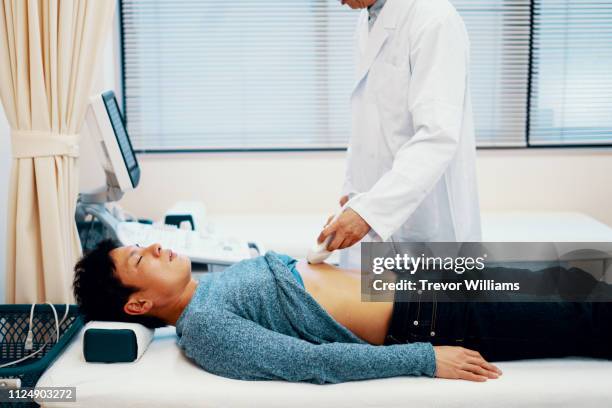 mid adult man get an abdominal ultrasound test in a hospital - abdomen scan stock pictures, royalty-free photos & images