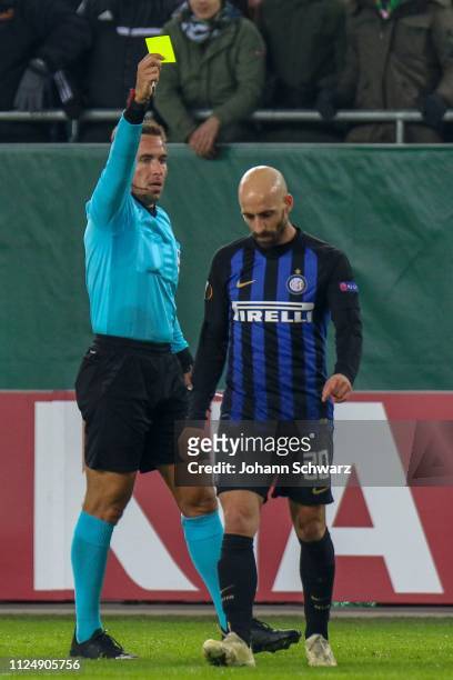 Referee Tobias Stieler of Germany shows Borja Valero of FC Internazionalethe yellow card during the UEFA Europa League Round of 32 match between SK...