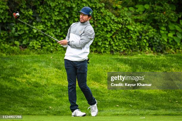 Actor Mark Wahlberg tees off on the eighth hole during the pro-am at practice for the Genesis Open at Riviera Country Club on February 13, 2019 in...
