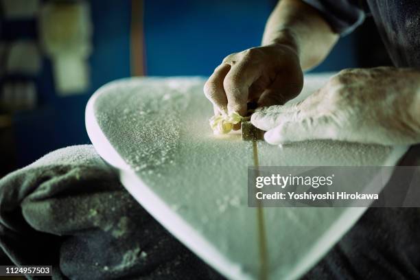 surfboard shaper planeing board in workshop for legendary surfer - moulant photos et images de collection