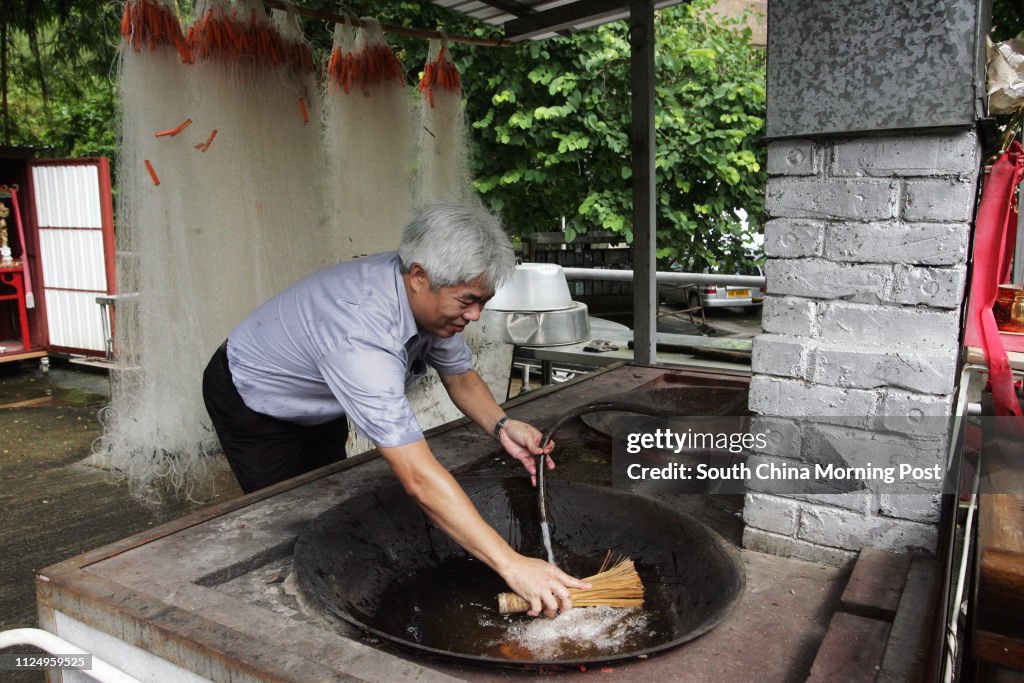 Head of Lam Tin Tsuen, Tang Kwok-kong, cleans the big wok and stove.  News Photo - Getty Images