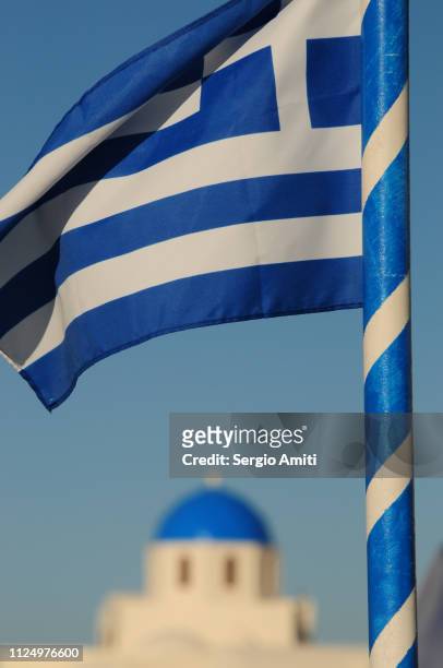 greek flag with blue domed church - flagpole sitting stockfoto's en -beelden