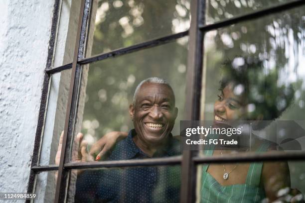 abuelo de latino hispano afro y nieta abrazando a través de la ventana - old man afro fotografías e imágenes de stock
