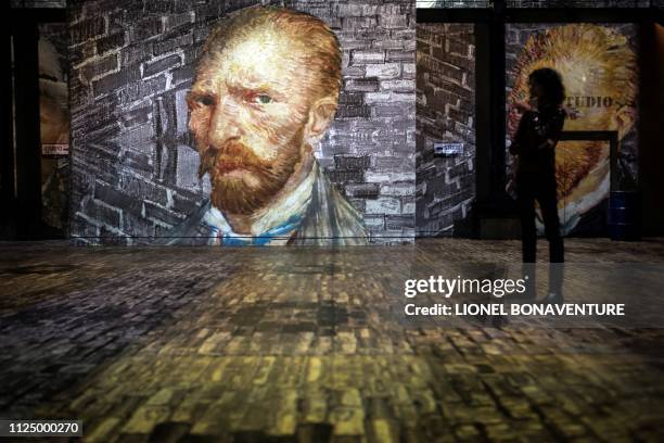 People attend a press visit of the immersive exhibition "Nuit Etoilée" devoted to painter Vincent Van Gogh by multimedia artist Gianfranco Iannuzzi,...