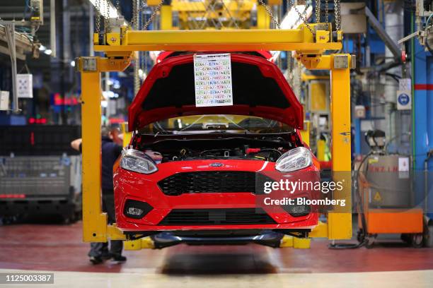 New red Ford Fiesta automobile hangs in a cradle on the assembly line at the Ford Motor Co. Factory in Cologne, Germany, on Wednesday, Feb. 13, 2019....