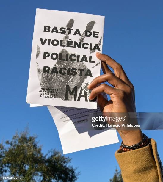 Demonstrator hoists an anti racism and police violence leaflet during the protest staged by residents of the impoverished Bairro da Jamaica , home to...