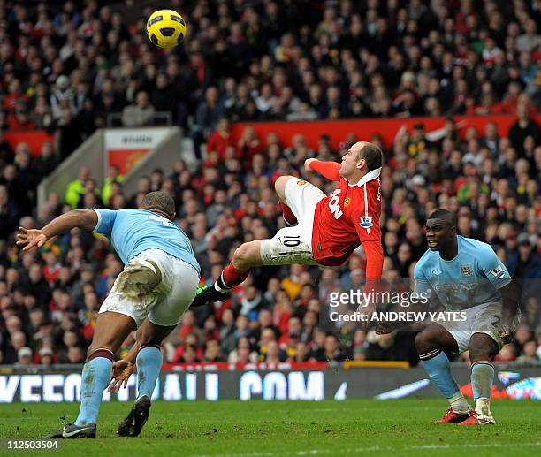 Manchester United's English striker Wayne Rooney scores their second goal between Manchester City's Belgian midfielder Vincent Kompany and English...