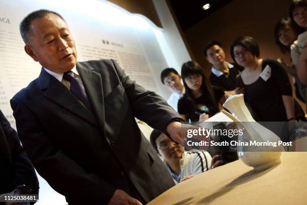 Member of the Underwater Archaeology Team of the National Museum of China, Xu Haibin explaining the details about the Ewer with handle and six...