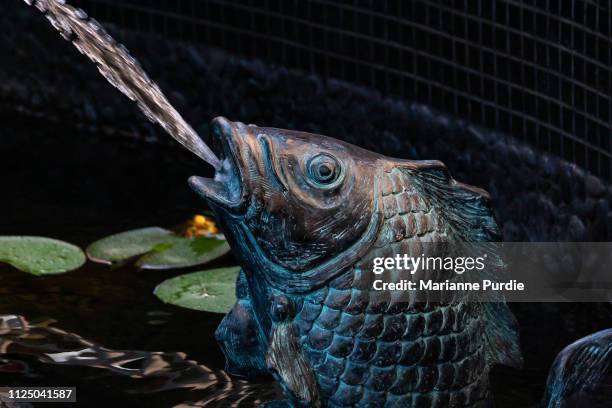 fountain in a fish pond - fountain stock pictures, royalty-free photos & images