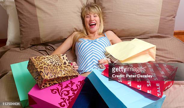 woman crashing out n bed after shopping trip - woman collapsing stock pictures, royalty-free photos & images