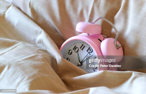 alarm clock in bed - bedtime stock pictures, royalty-free photos & images