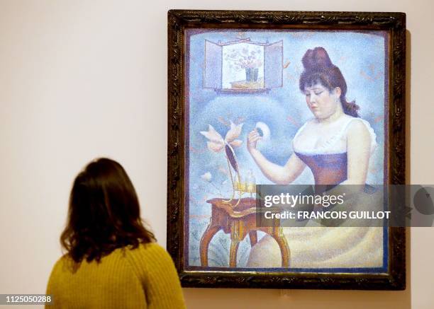 Visitor looks at the painting "Young Woman Powdering Herself " by French painter Georges Seurat during the press visit of the exhibition "The...