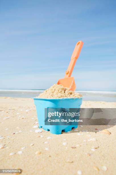 sand pail and shovel on the beach - beach shovel stockfoto's en -beelden