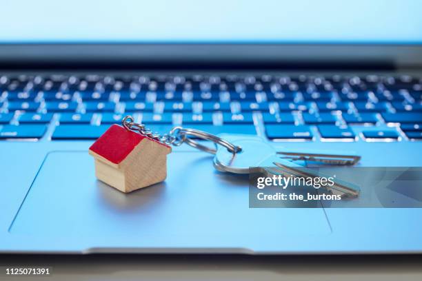 still life of key ring with a small house and keys on laptop computer - house key 個照片及圖片檔