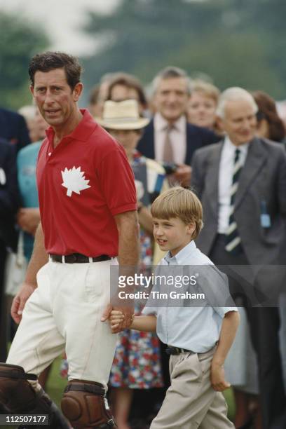 Prince Charles holding the hand of his son, Prince William, at a polo match in Windsor, Berkshire, England, Great Britain, 16 June 1990.