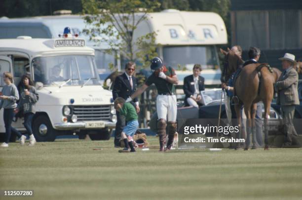 Prince William cowers as his father, Prince Charles, grabs him by the neck, in the grounds of Windsor Castle, where they were attending a polo match,...