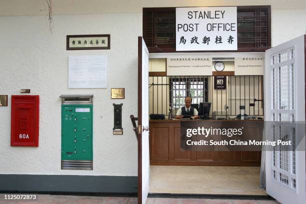 Postmater Lee Wing-tai working in the Stanley Post Office, which is restored to the same look it had when first established in 1937, with old style...