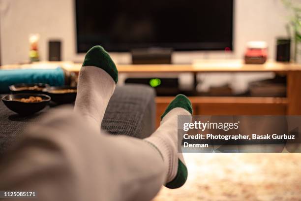 watching television relaxed at home - voeten omhoog stockfoto's en -beelden