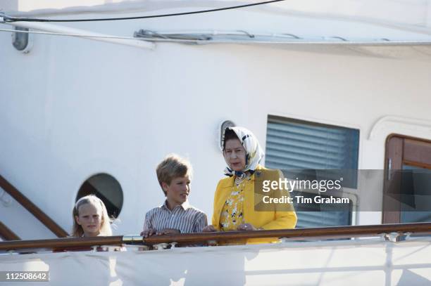 Zara Phillips with her brother, Peter Philips, and their grandmother, Queen Elizabeth II, on board the Royal yacht Britannia at the start of a...