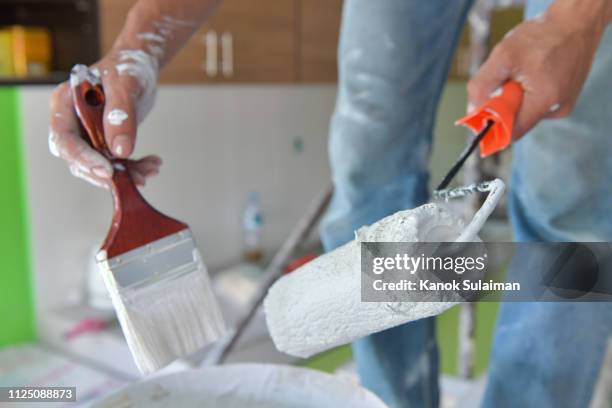 painter with paint brush and roller - wall building feature 個照片及圖片檔