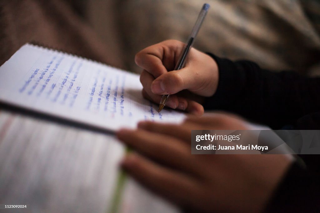 Teenager hands writing in a notebook.  He is doing the tasks of the institute.  Spain