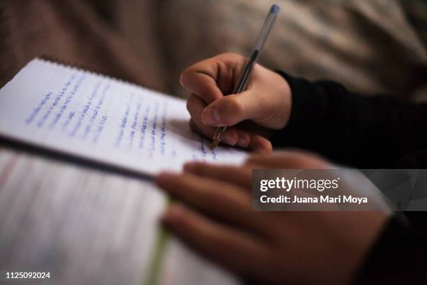 teenager hands writing in a notebook. he is doing the tasks of the institute. spain - mari letters stock pictures, royalty-free photos & images