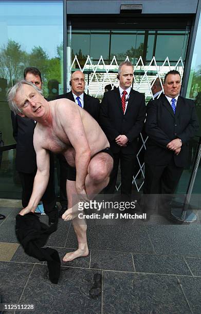 Kit Fraser from Inverness removes his clothes in protests outside the Royal Bank of Scotland annual meeting on April 19, 2011 in Edinburgh....