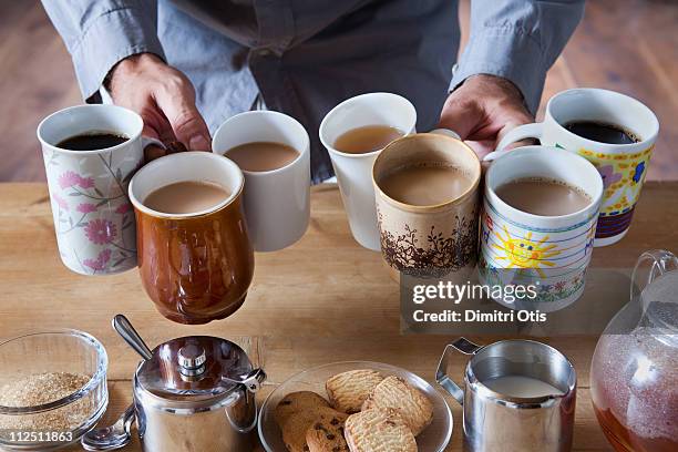 man holding many tea and coffee cups - cup on the table stock pictures, royalty-free photos & images