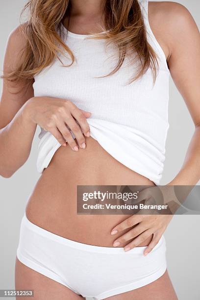 woman showing her flat stomach - flat stomach stockfoto's en -beelden