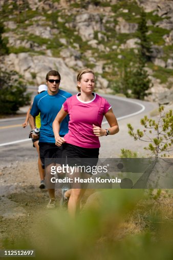 Group running on trails in mountains.