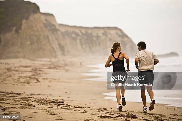 man and woman running on beach. - half moon bay antigua stock pictures, royalty-free photos & images