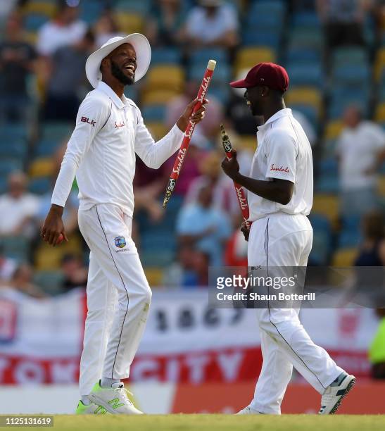 Roston Chase of West Indies celebrates at the end of the match with team-mate Kemar Roach after taking 8 wickets for 60 runs at the end of Day Four...