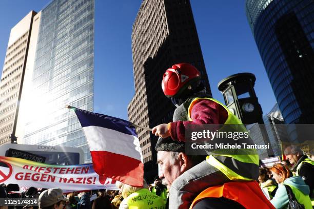 A Child waves a French national Flag as Supporters of the new left-wing "Stand Up" movement gather at a demonstration at Potsdamer Platz on February...