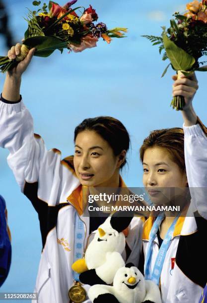 Wu Minxia and Guo Jingjing of China wave after receiving their gold medals for the women's three meters sychronized diving final at Sajik pool in...