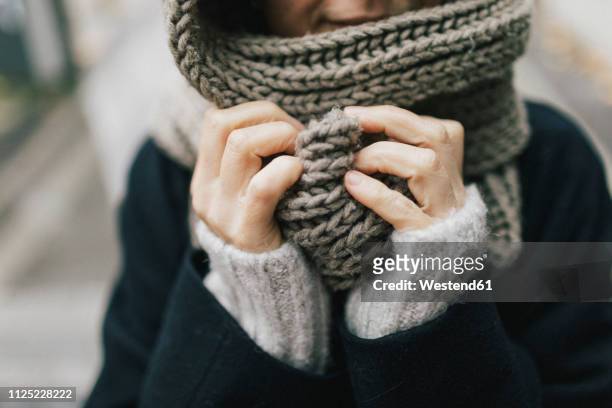 woman's hand holding knitted scarf, close-up - froid photos et images de collection