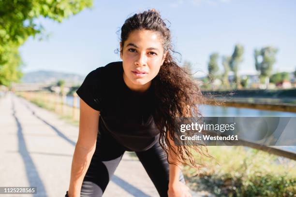 portrait of sportive young woman having a break at the riverside - finishing workout stock pictures, royalty-free photos & images