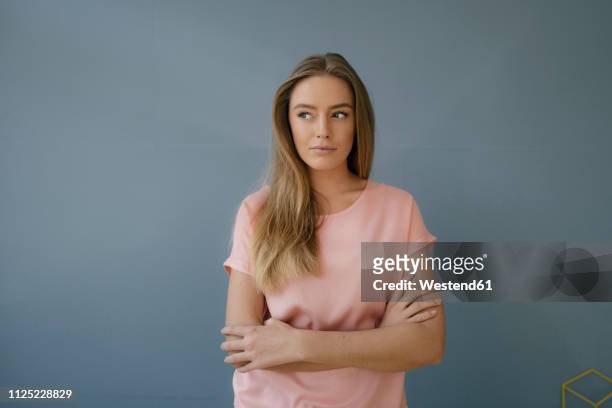 portrait of young woman wearing pink t-shirt - regard de côté studio photos et images de collection