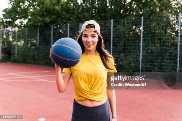 happy young woman playing basketball - basketball sport stock-fotos und bilder