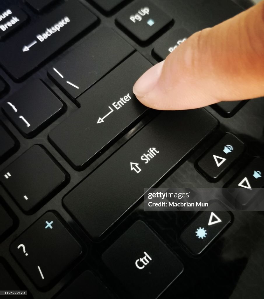 Finger on enter key on a laptop keyboard