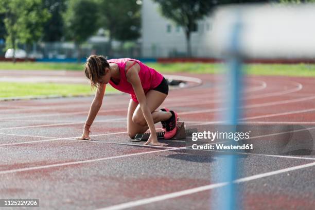 teenage runner training start on race track - girls on train track stock-fotos und bilder