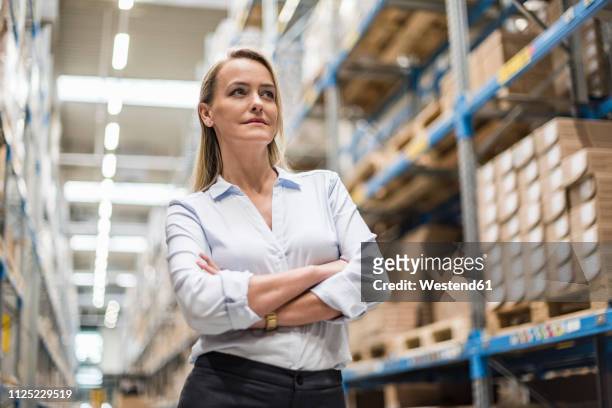 portrait of confident woman in factory storehouse - metallic blouse stock pictures, royalty-free photos & images