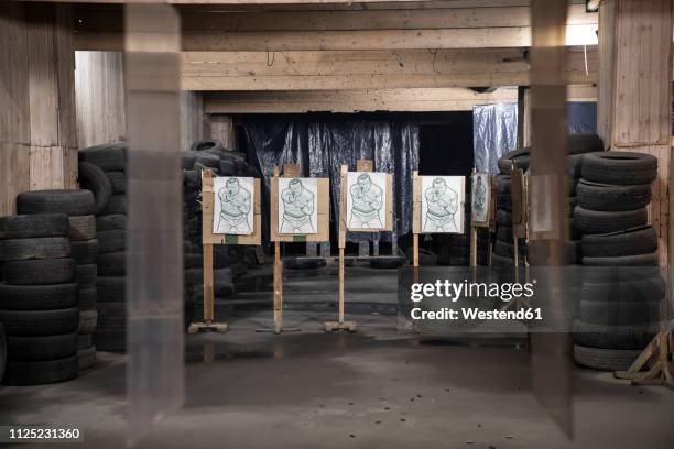 boards with male likeness as targets in an indoor shooting range - male likeness fotografías e imágenes de stock