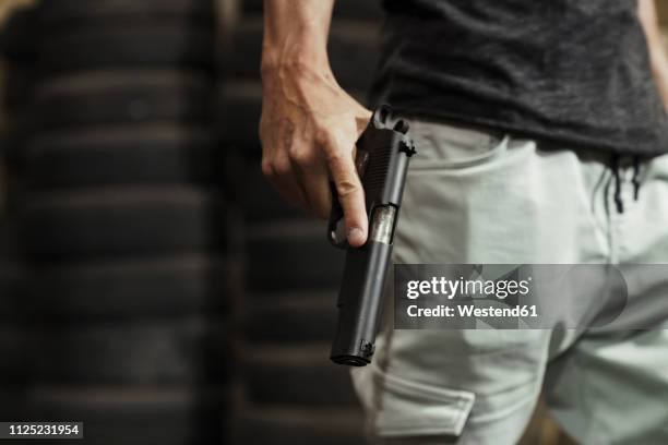 close-up of man holding a pistol - gun violence stock pictures, royalty-free photos & images