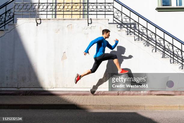 sportive man exercising on pavement - center athlete stock pictures, royalty-free photos & images