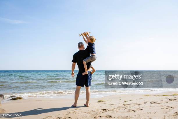 father and son playing at the beach - spring denmark stock pictures, royalty-free photos & images