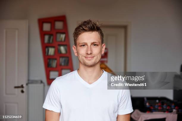 portrait of smiling young man at home - jeunes hommes photos et images de collection