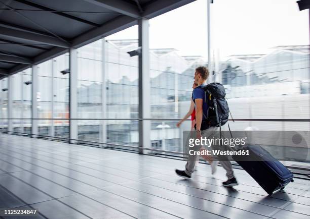 couple walking fast at the airport - rollkoffer stock-fotos und bilder
