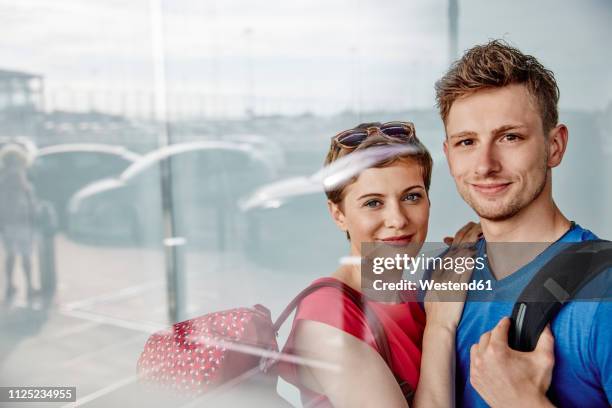 portrait of smiling couple at the airport - airport parking stock-fotos und bilder