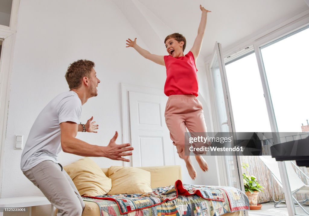Excited couple in living room at home